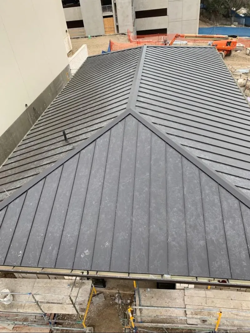 Commercial metal roof construction with crane equipment in Lompoc